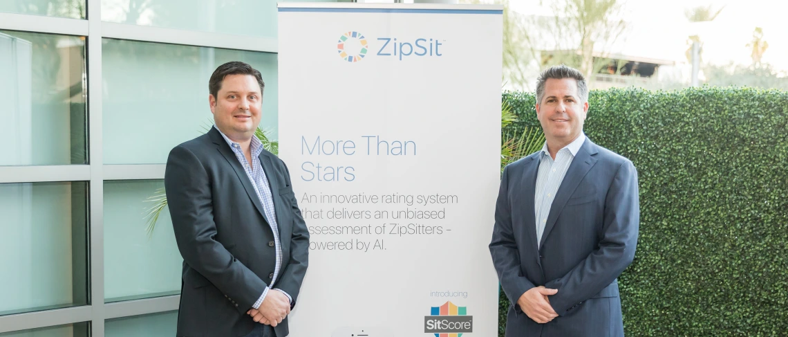 Zipsit founders standing in front of a sign.
